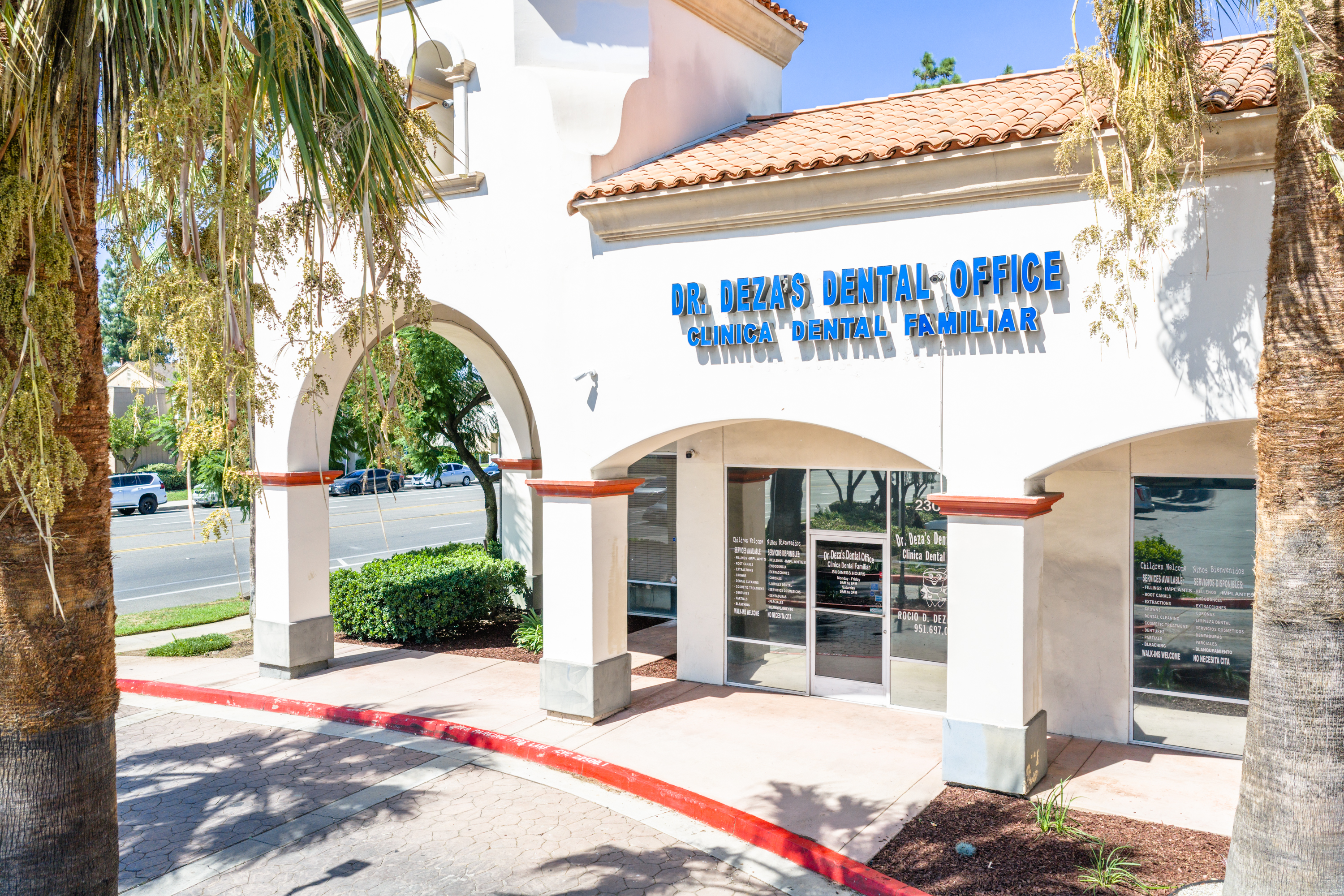 Dr. Deza's dental office at Plaza Del Sol, set behind palms and landscaping