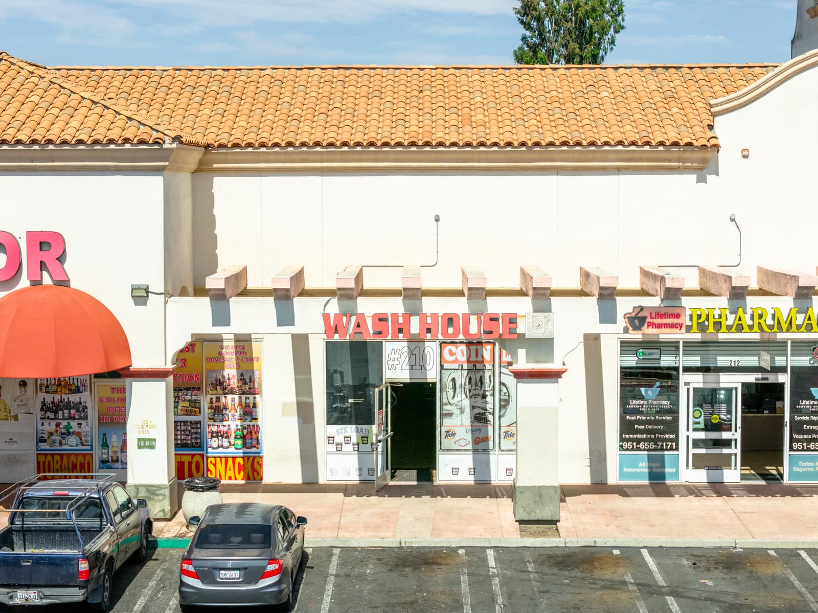 Wash House laundry and the pharmacy storefronts along the Plaza Del Sol arcade